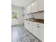 Laundry room with patterned tile floor, wooden countertop, cabinets and sink at 110 Keswick Way, Alpharetta, GA 30022