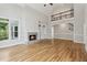 Bright living room featuring a stone fireplace, built-in shelving, and a large window with outside views at 110 Keswick Way, Alpharetta, GA 30022