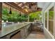 Well-equipped outdoor kitchen featuring stone accents, granite countertops, and a stainless steel grill at 110 Keswick Way, Alpharetta, GA 30022