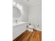 Half bathroom with hardwood floors and a decorative mirror at 110 Keswick Way, Alpharetta, GA 30022