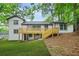 Backyard featuring white painted brick home with wood deck and steps, mature trees and a well manicured lawn at 2813 Hillside Rd, Smyrna, GA 30080