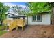 Backyard featuring white painted brick home with wood deck and steps leading to a well manicured lawn at 2813 Hillside Rd, Smyrna, GA 30080