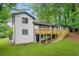 Backyard featuring white painted brick home with wood deck and steps, mature trees and a well manicured lawn at 2813 Hillside Rd, Smyrna, GA 30080