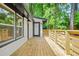 Side of house features a light wood deck with white painted brick exterior, black trim and a glass paned door at 2813 Hillside Rd, Smyrna, GA 30080