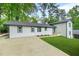 Back of home featuring white painted brick, black trim, well manicured lawn and a large concrete driveway at 2813 Hillside Rd, Smyrna, GA 30080