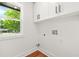 Clean laundry area with white cabinetry, hardwood floors, and a bright window at 2813 Hillside Rd, Smyrna, GA 30080