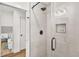 Close-up of an elegant shower with gray tiles, a glass door, and black fixtures at 2813 Hillside Rd, Smyrna, GA 30080