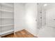 Walk-in closet features built-in shelving and hanging space adjacent to a modern white bathroom with a glass shower at 2813 Hillside Rd, Smyrna, GA 30080