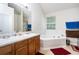 Bright bathroom with double sinks, large mirror, and separate tub at 5857 Cobalt Dr, Powder Springs, GA 30127