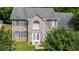 Two-story brick home with grey shutters and gabled entrance is surrounded by mature trees at 5857 Cobalt Dr, Powder Springs, GA 30127
