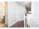 Second-floor hallway with white railings, neutral carpet, and doorways at 5857 Cobalt Dr, Powder Springs, GA 30127
