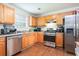 Well-equipped kitchen featuring stainless steel appliances, wood cabinets, and hardwood floors at 5857 Cobalt Dr, Powder Springs, GA 30127