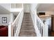 Carpeted staircase with white wood banister leads to the second floor, with views to stainless fridge at 5857 Cobalt Dr, Powder Springs, GA 30127