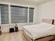 Bedroom with white bedding, dark wood floors, and modern black blinds at 2964 Old Peachtree Rd, Dacula, GA 30019