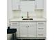 This laundry room has white shaker cabinets, chrome hardware, and a stainless steel sink at 2964 Old Peachtree Rd, Dacula, GA 30019