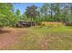 Spacious backyard featuring a home with an elevated deck, lush trees, and a wooden fence at 263 Lynn Dr, Fayetteville, GA 30215