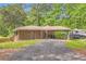 Wide gravel driveway leading to a cozy home with a covered carport perfect for vehicles or outdoor hobbies at 263 Lynn Dr, Fayetteville, GA 30215