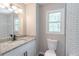 Bathroom vanity features neutral granite countertops, modern fixtures, subway tile, and window at 5139 Coolamber Dr, Powder Springs, GA 30127