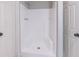 Bright white bathroom featuring a shower stall with built-in seating, chrome fixtures and white doors at 5139 Coolamber Dr, Powder Springs, GA 30127