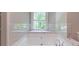 This luxurious bathroom features a stand alone tub under a picture window with marble trim at 5139 Coolamber Dr, Powder Springs, GA 30127