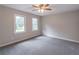 A well lit bedroom features neutral walls, gray carpet, windows, ceiling fan and light fixture at 5139 Coolamber Dr, Powder Springs, GA 30127
