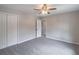 Bedroom with gray carpet, neutral paint, ceiling fan, closet, and view to second floor hallway at 5139 Coolamber Dr, Powder Springs, GA 30127