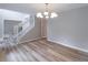 This brightly lit dining room is illuminated by a modern chandelier and features wood floors and neutral paint at 5139 Coolamber Dr, Powder Springs, GA 30127