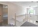 This bright upstairs hallway features neutral paint, carpeted floors and a view of the front yard at 5139 Coolamber Dr, Powder Springs, GA 30127