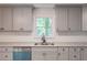 This well-lit kitchen features modern grey cabinets, granite countertops and a large sink under a window at 5139 Coolamber Dr, Powder Springs, GA 30127