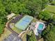 Aerial view of community amenities, including a pool, tennis court, playground, and clubhouse, surrounded by trees at 6990 N Glen Dr, Cumming, GA 30028