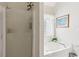 Bright bathroom with a large soaking tub, tiled shower, and frosted glass door at 6990 N Glen Dr, Cumming, GA 30028