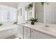 Bright bathroom with double vanity, garden tub, and white cabinets at 6990 N Glen Dr, Cumming, GA 30028