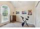 Bedroom featuring an arched window, light beige walls, gray carpet, and a blue exercise bike at 6990 N Glen Dr, Cumming, GA 30028