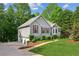 Side view of a well-maintained home with a three-car garage and lush green lawn at 6990 N Glen Dr, Cumming, GA 30028
