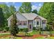 Charming two-story home with lush landscaping, red shutters, and stone accents at 6990 N Glen Dr, Cumming, GA 30028