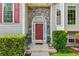 Charming red front door with stone archway and decorative shrubbery at 6990 N Glen Dr, Cumming, GA 30028