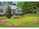 Charming two-story home with lush landscaping, red shutters, and stone accents at 6990 N Glen Dr, Cumming, GA 30028