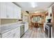 Modern kitchen with white cabinets, stainless steel appliances, and an adjacent dining area at 6990 N Glen Dr, Cumming, GA 30028