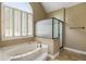 Bathroom with soaking tub, glass shower, and plantation shutters at 2912 Dunhill Trl, Woodstock, GA 30189