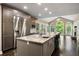 Gourmet kitchen features a large island, granite countertops, stainless appliances, and access to the living room at 2912 Dunhill Trl, Woodstock, GA 30189