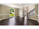 Spacious living room featuring hardwood floors, large arched window, and staircase with iron balusters at 2912 Dunhill Trl, Woodstock, GA 30189