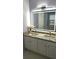 Bathroom featuring a granite countertop, double sinks, cabinet storage, and a large LED mirror at 3315 Haverhill Rowe, Lawrenceville, GA 30044