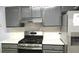 Modern kitchen featuring stainless steel range with gray cabinetry and white countertop at 3315 Haverhill Rowe, Lawrenceville, GA 30044