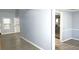Open-concept living room featuring natural light, light blue walls, and luxury vinyl plank flooring at 3315 Haverhill Rowe, Lawrenceville, GA 30044