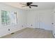 A bright bedroom featuring wood-look floors, a ceiling fan, and natural light at 4011 Lake Carlton Rd, Loganville, GA 30052