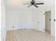 Well lit bedroom with wood-look floors, a ceiling fan, and a closet at 4011 Lake Carlton Rd, Loganville, GA 30052