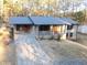 A front exterior featuring a two-story brick home with a long driveway and well-lit windows at 4011 Lake Carlton Rd, Loganville, GA 30052