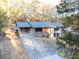 An exterior view of a brick home with a long driveway, a cozy covered porch, and lots of natural light at 4011 Lake Carlton Rd, Loganville, GA 30052