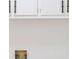 Wall in laundry room featuring electrical outlet, plumbing and white cabinets at 4011 Lake Carlton Rd, Loganville, GA 30052