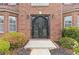 Close-up of an elegant double-door entrance framed by lush greenery and tasteful landscaping at 6932 Dalehollow Dr, Lithonia, GA 30058